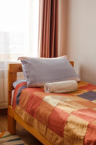 a bed with a colorful blanket and a window at Guest House Altyn Oimok in Bokonbayevo