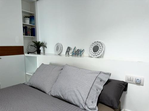 een slaapkamer met een bed met een witte muur bij Apartamento Playa chica, vistas al mar Lanzarote in Puerto del Carmen