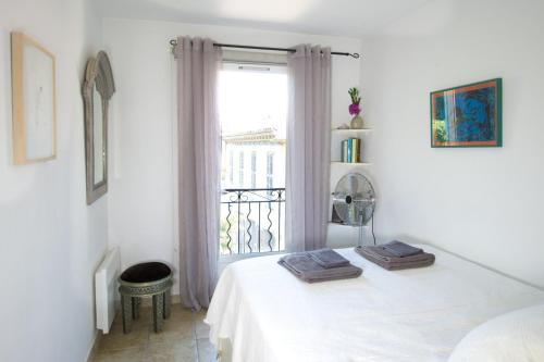 a white room with a bed and a window at Rue Sade Bed & Breakfast in Antibes