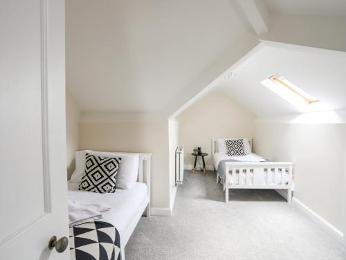 a white room with two beds and a table at Gwynant - Bull Bay in Amlwch