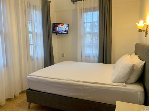 a bedroom with a bed with a tv on the wall at Sabah Pension in Antalya