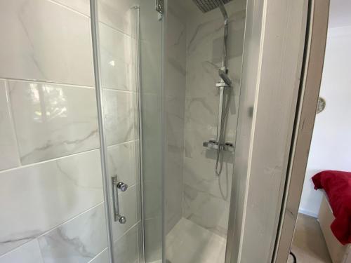 a shower with a glass door in a bathroom at Stylish 4 Bedroom House with Private Parking and Free WiFi in Milton Keynes by HP Accommodation in Milton Keynes