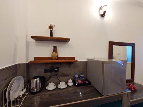 a kitchen with a counter with a mirror and a sink at CHEN VILLA - Near Airport in Negombo