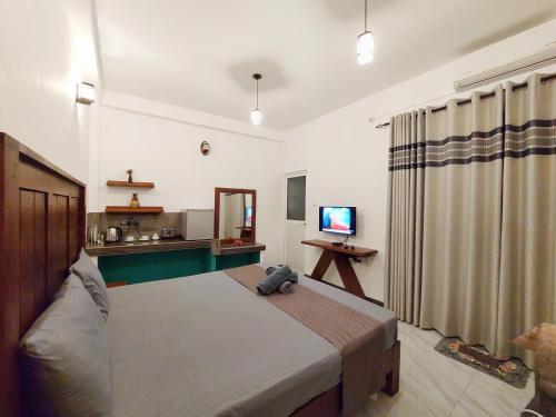 a bedroom with a bed and a television in it at CHEN VILLA - Near Airport in Negombo
