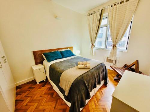 1 dormitorio con 1 cama grande con almohadas azules en Sala e quarto entre Copacabana e Ipanema ao lado Arpoador, en Río de Janeiro
