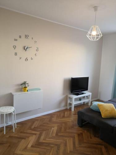 sala de estar con reloj en la pared en Apartament Gdańsk 10 min piechotą od morza en Gdansk