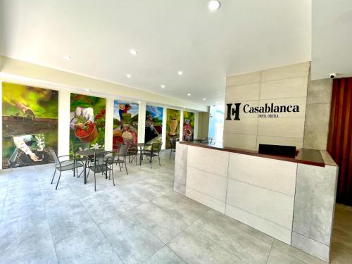 a lobby with a restaurant with a table and chairs at HOTEL CASABLANCA in Xilitla