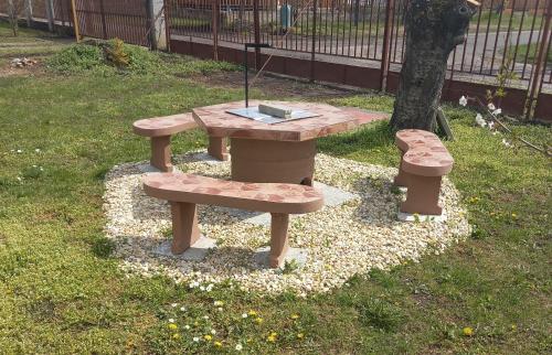 una mesa de picnic y dos bancos en un parque en Barázda Apartman en Berekfürdő