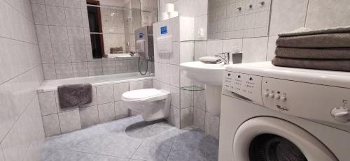 a bathroom with a toilet and a sink and a washing machine at Playa Apartament z parkingiem, Promenadą do Mola in Gdańsk