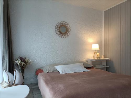 sypialnia z łóżkiem i lustrem na ścianie w obiekcie Charmant Appartement Bord de mer w Argelès-sur-Mer