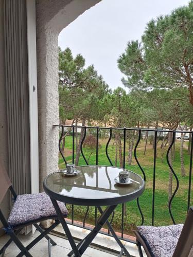 d'une table et de deux chaises sur un balcon avec une fenêtre. dans l'établissement Charmant Appartement Bord de mer, à Argelès-sur-Mer