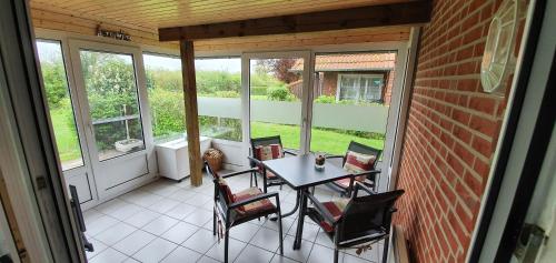 un patio con mesa y sillas en un porche en Kaept-n-Hook, en Lemkendorf