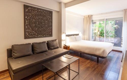 salon z kanapą i łóżkiem w obiekcie Hotel Derby w Barcelonie
