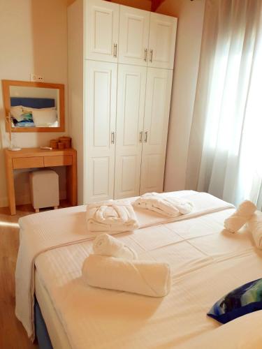 two white towels on two beds in a room at Reiki Apartments Erikousa in Ereikoússa