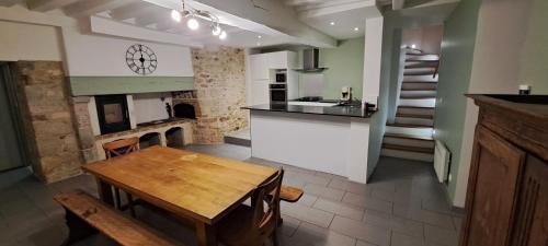 - une cuisine avec une table en bois et un comptoir dans l'établissement Au Coin du Feu, à Châtillon-sur-Marne