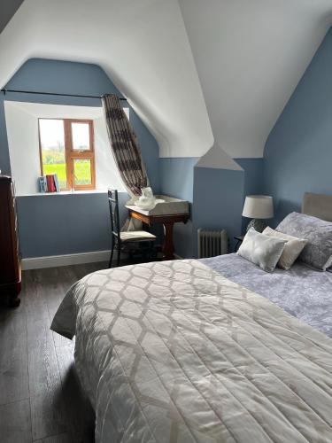 a bedroom with a bed and a chair and a window at Stone Lodge B&B in Balrath