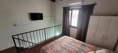 um quarto com uma cama e uma televisão na parede em Depto de La Lila em Salta