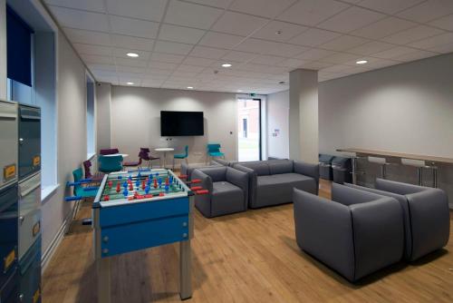 a room with a foosball table and couches at UPP Bay Campus Swansea in Swansea