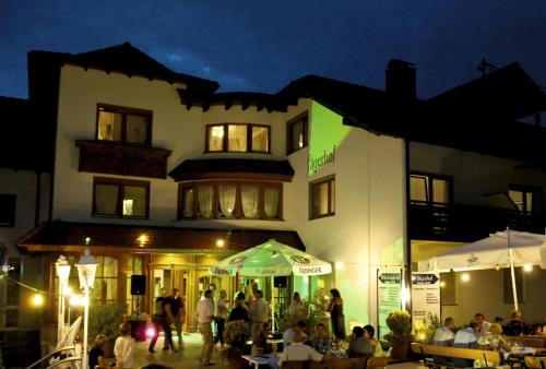 een groep mensen die 's nachts buiten een gebouw staan bij Hotel Badischer Hof in Biberach bei Offenburg