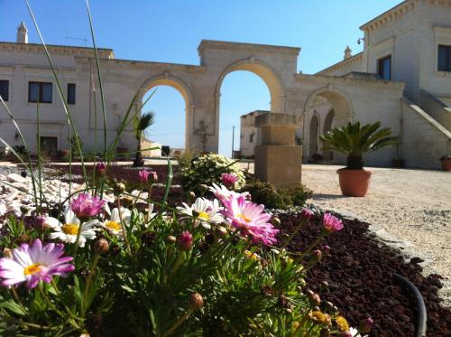 a garden with flowers in front of a building at Agriturismo I Pozzetti in Savelletri di Fasano