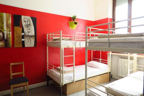 a room with two bunk beds and a red wall at Koala Hostel in Milan