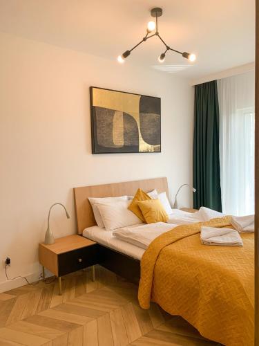 a bedroom with a large bed with a yellow blanket at APARTAMENTY KALINA z widokiem na góry - Kilińskiego 2A in Świeradów-Zdrój