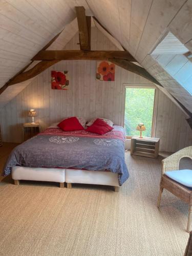 a bedroom with a large bed in a attic at Le Nid de Bercé in Jupilles