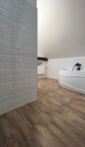 a bathroom with a bath tub on a wooden floor at Hotel & Cafe SokoLOVE in Sokolov