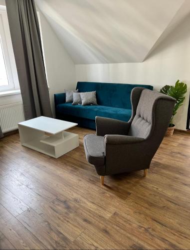 a living room with a blue couch and a coffee table at Hotel & Cafe SokoLOVE in Sokolov
