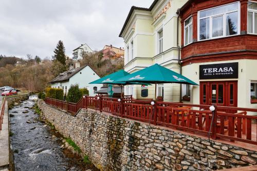 un restaurant avec des parasols en face d'un bâtiment dans l'établissement Hotel Terasa, à Vimperk