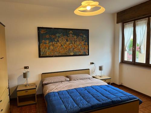 - une chambre dotée d'un lit bleu et d'une peinture murale dans l'établissement Bella Vista, à Baveno