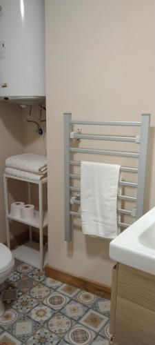 a bathroom with a toilet and a sink and towels at El Volante Alojamiento Turístico in Villafranca del Bierzo