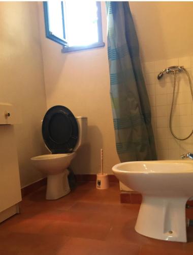 une salle de bain avec toilettes, lavabo et fenêtre dans l'établissement Appartements bord de mer - Accès privé à la plage, à Prunete