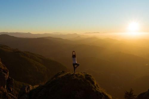 a woman standing on top of a mountain at sunset at Villa Podere Gaia 16 Pax by VILLASRETREATS in Sasseta
