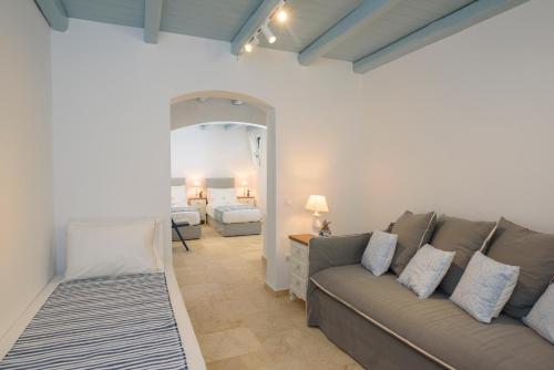 ein Wohnzimmer mit Sofa und ein Schlafzimmer in der Unterkunft Tholariani Villas in Amorgós
