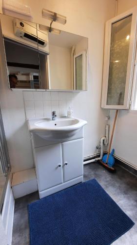 La salle de bains est pourvue d'un lavabo blanc et d'un miroir. dans l'établissement PROMO 27-31 mai Toulouse 15 mn appart 3 lits propre cuisine sde 4 personnes, à Montastruc-la-Conseillère