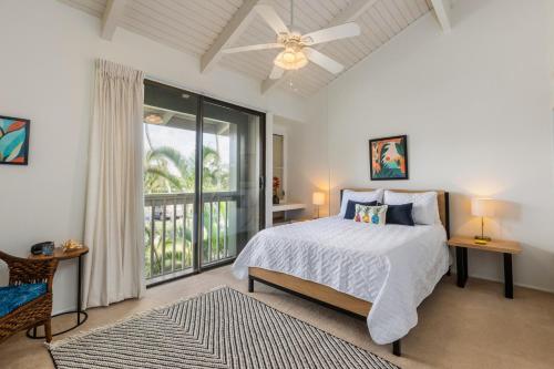 een slaapkamer met een bed en een groot raam bij Beautiful Golf Course front near the beach in Kahuku