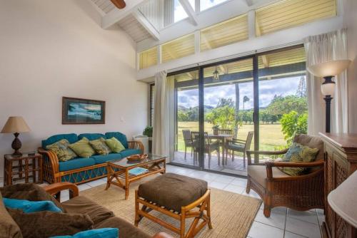 a living room with a blue couch and a table at Fantastic Location on the golf course near the beach in Kahuku