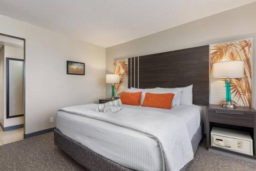 a bedroom with a large white bed with orange pillows at Incredible Location FREE parking in Waikiki in Honolulu