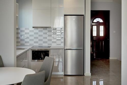 a stainless steel refrigerator in a kitchen with a table at Sunbreeze Delux Vilas in Budva