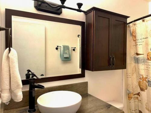 a bathroom with a toilet and a sink and a mirror at Relaxing Turtle Bay townhome near the beach in Kahuku