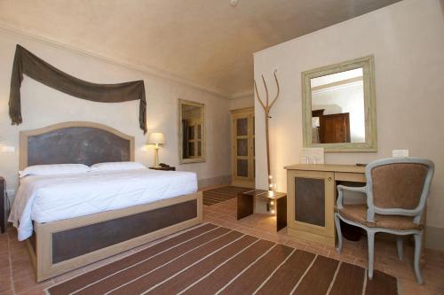a bedroom with a bed and a desk and a mirror at Hotel San Giovanni Resort in Saluzzo