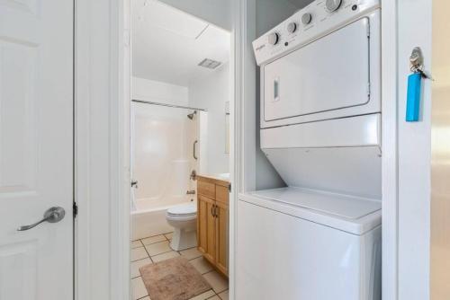 a bathroom with a white refrigerator and a toilet at Tropical Getaway perfect for families in Kahuku