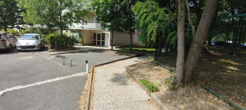 a parking lot with a car parked in front of a building at Design 3 bedrooms appartment, near Champs Elysees in Nanterre