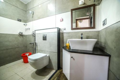 uma casa de banho com um WC, um lavatório e um espelho. em The GreenStay em Sakleshpur