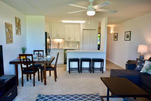 a living room with a couch and a table and a kitchen at Beach Glam at Turtle Bay on the golf course in Kahuku