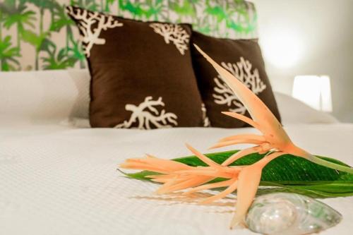 a flower sitting on top of a bed at Hermosa Beach House in Playa Hermosa