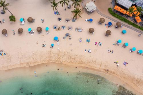 an aerial view of a beach with a group of people at Beach Glam at Turtle Bay on the golf course in Kahuku