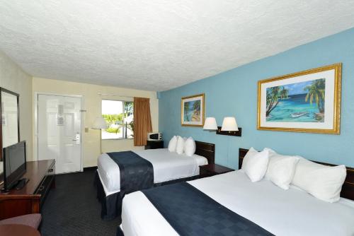 a hotel room with two beds and a television at Americas Best Value Inn Bradenton-Sarasota in Bradenton
