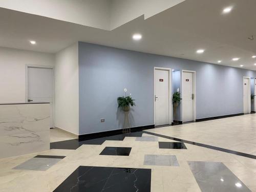 a lobby with white walls and doors with potted plants at Hotel Barranquilla Laank in Barranquilla